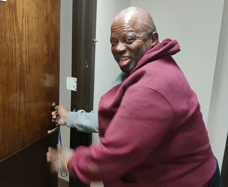 Man opening door to his new apartment.