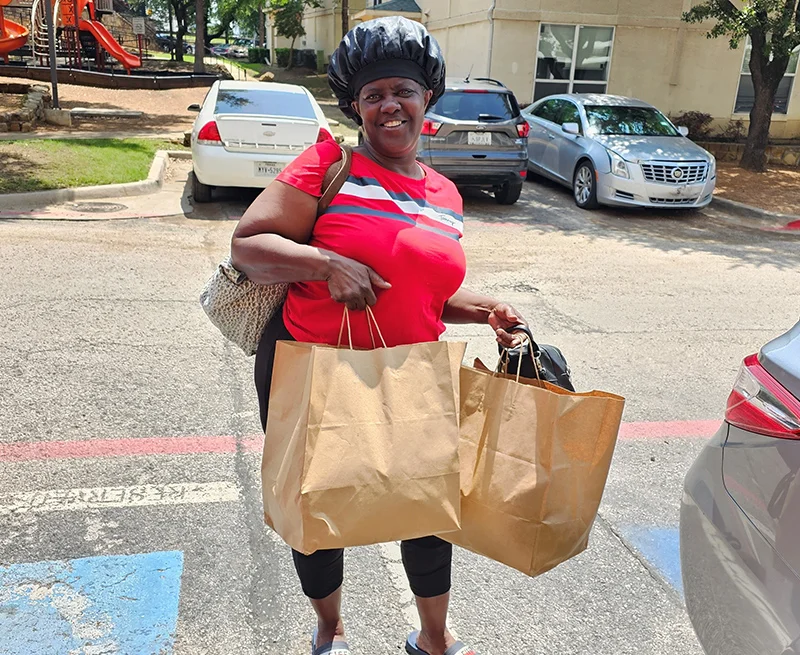 Woman holding groceries for her new home, after being a guest at The Bridge Homeless Recovery Shelter.