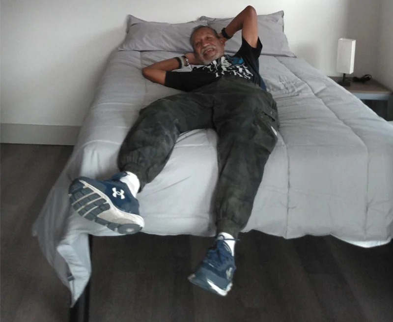 Man laying in bed in new apartment.